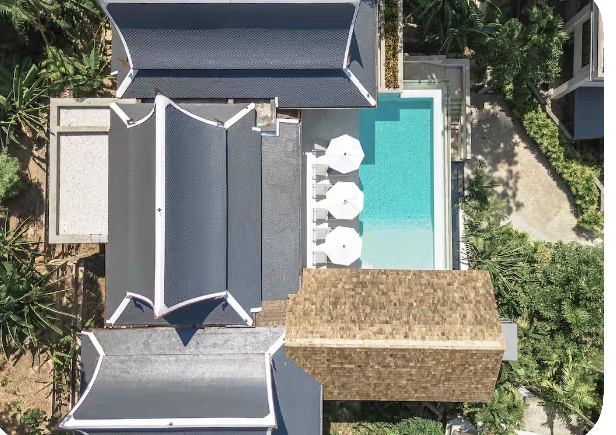 Aerial view of the villa's Thai-style roofs and infinity pool
