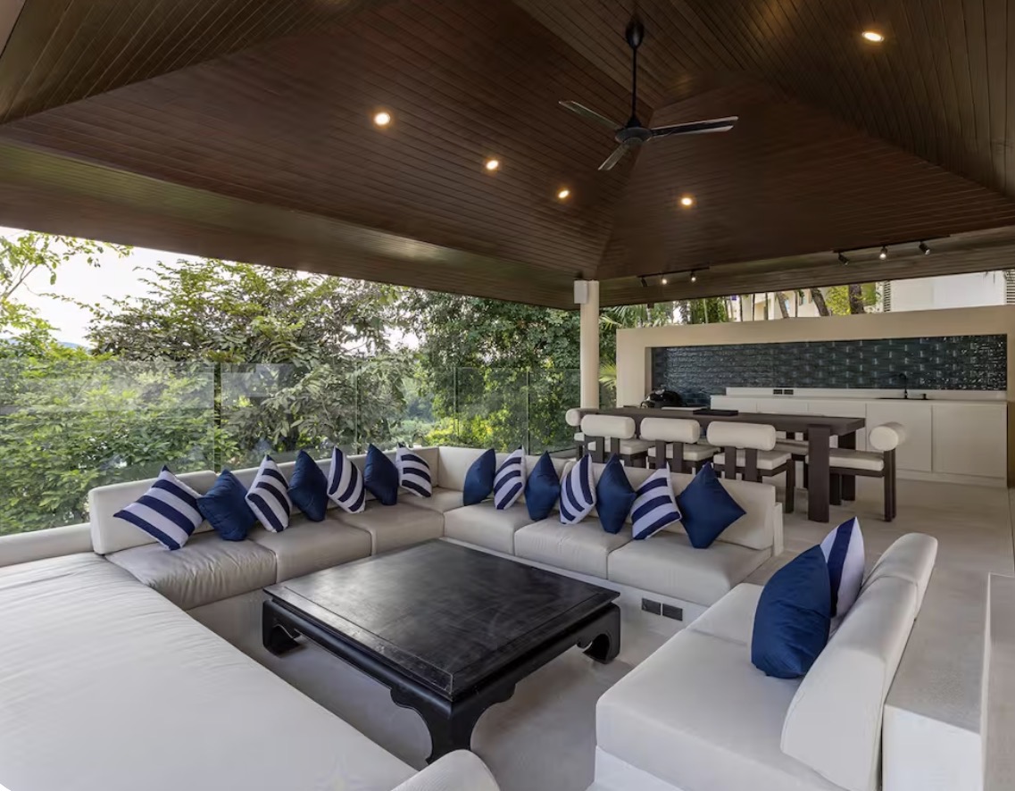 Covered outdoor lounge with navy cushions, bar and dining table